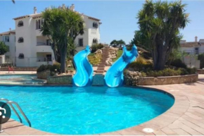 En Denia, urbanización el palmar con piscina, toboganes y chiringuito